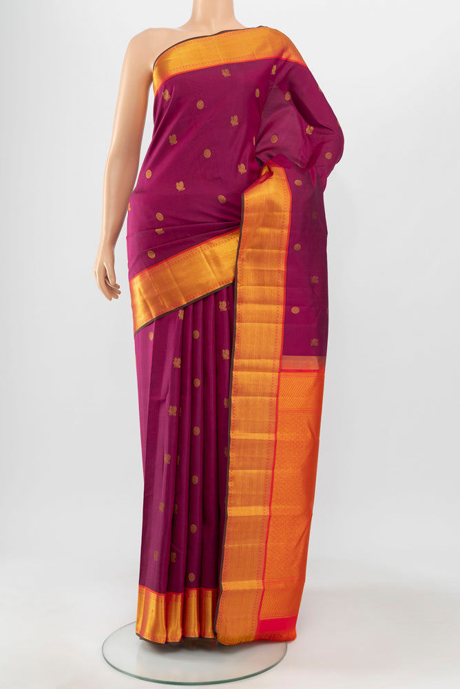Magenta Kanchipuram Silk Saree with Zari Butta on the body and Silk Border.  displayed on a mannequin