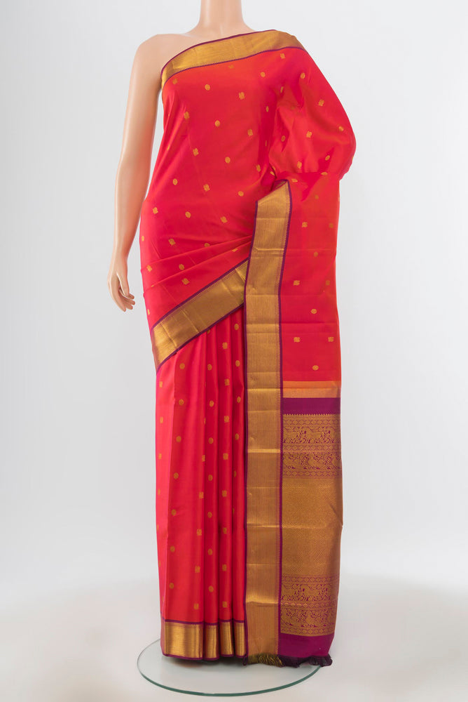 Pure Silk Pure Zari Peach Kanjivaram Saree with Zari Butta on the body and Silk Border.  displayed on a mannequin