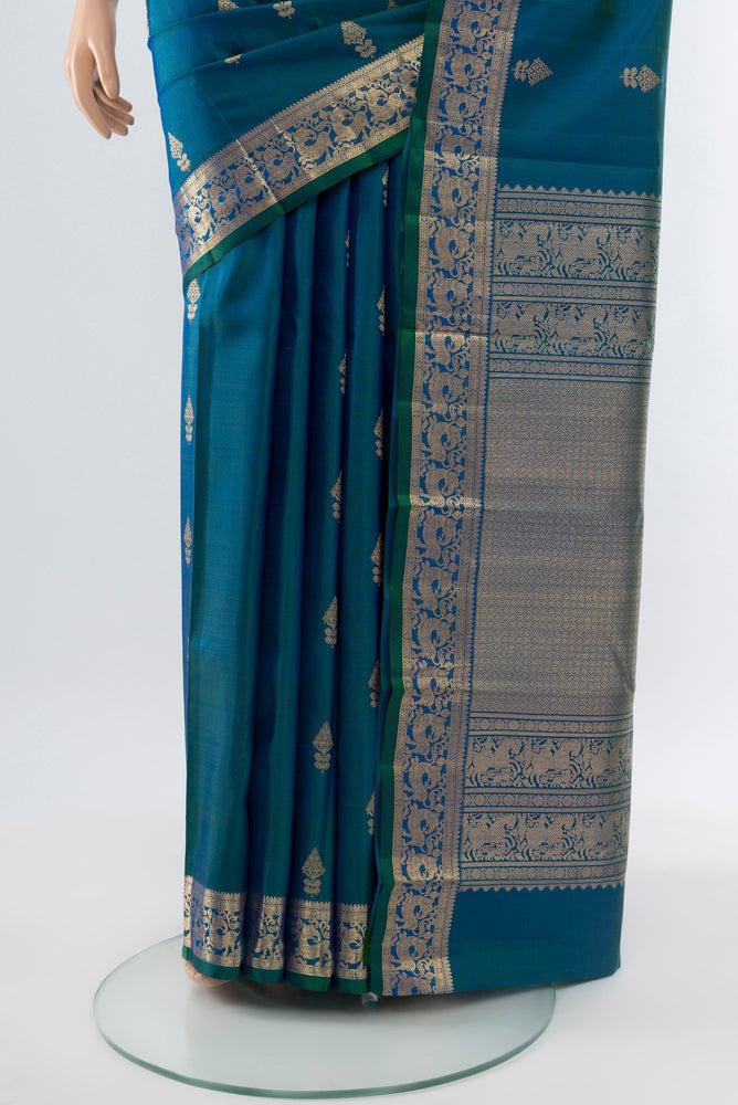 Pleats and pallu of Peacock Blue Kanjivaram Silk Saree with Zari Butta on the body and Silk Border. 