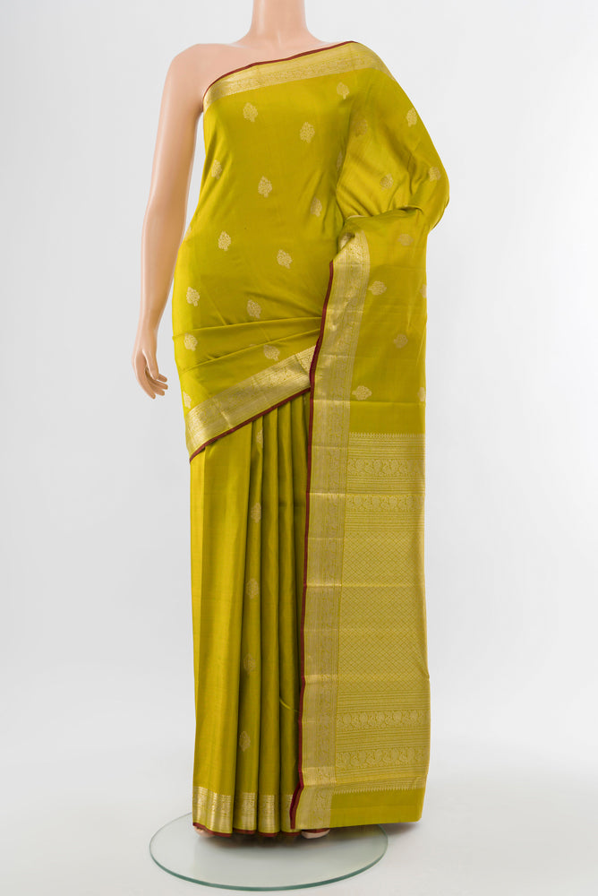 Light Green Kanjivaram Silk Saree with Zari Butta on the body and Silk Border.  displayed on a mannequin