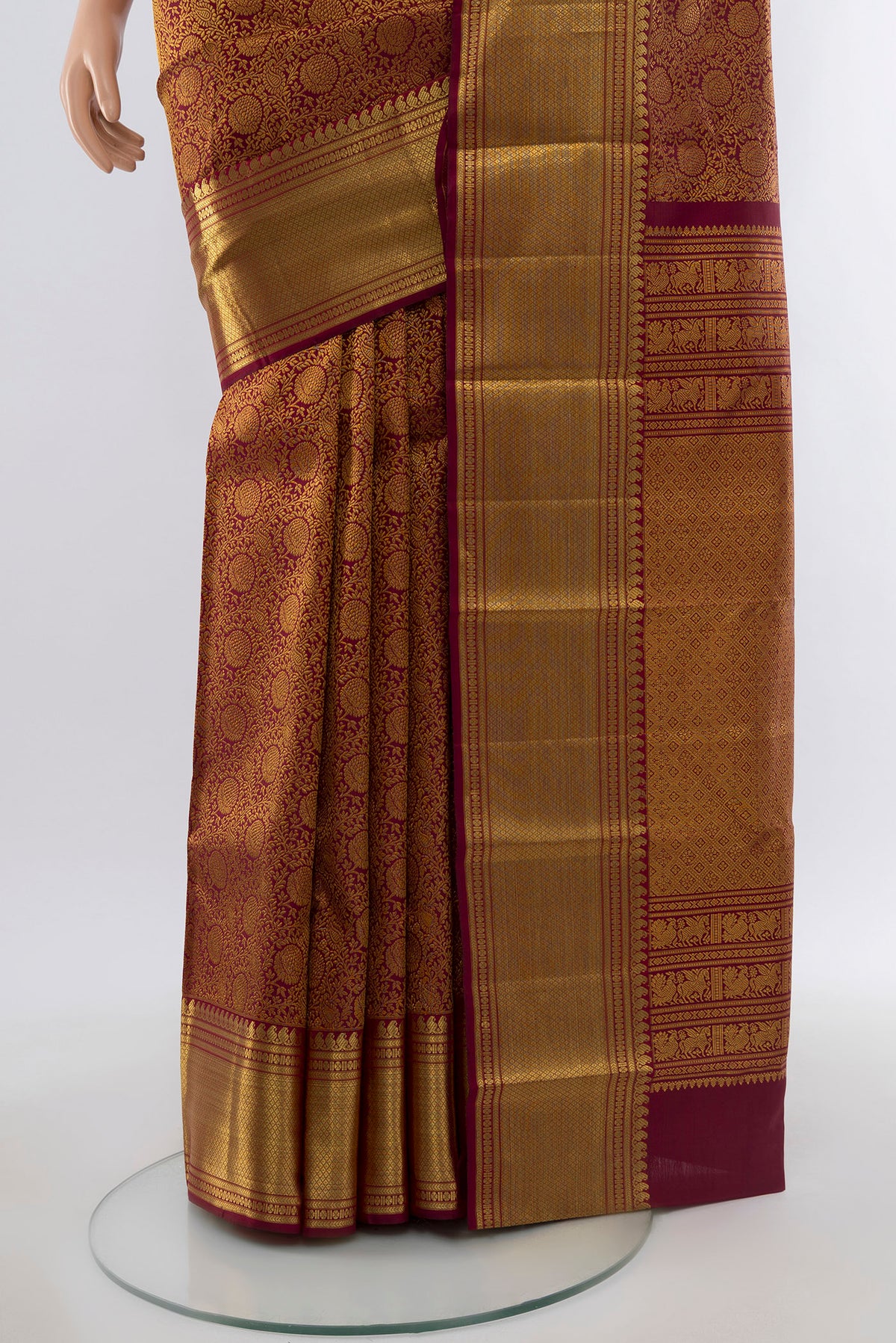 Pleats and pallu of Maroon Kanchipuram Silk Saree with Zari Butta on the body and Silk Border. 