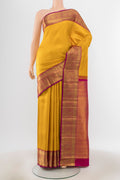 Mustard Kanchipuram Silk Saree with Zari Butta on the body and Silk Border.  displayed on a mannequin