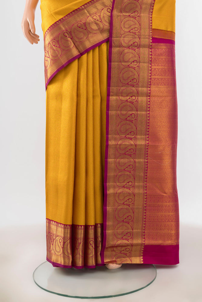 Pleats and pallu of Mustard Kanchipuram Silk Saree with Zari Butta on the body and Silk Border. 