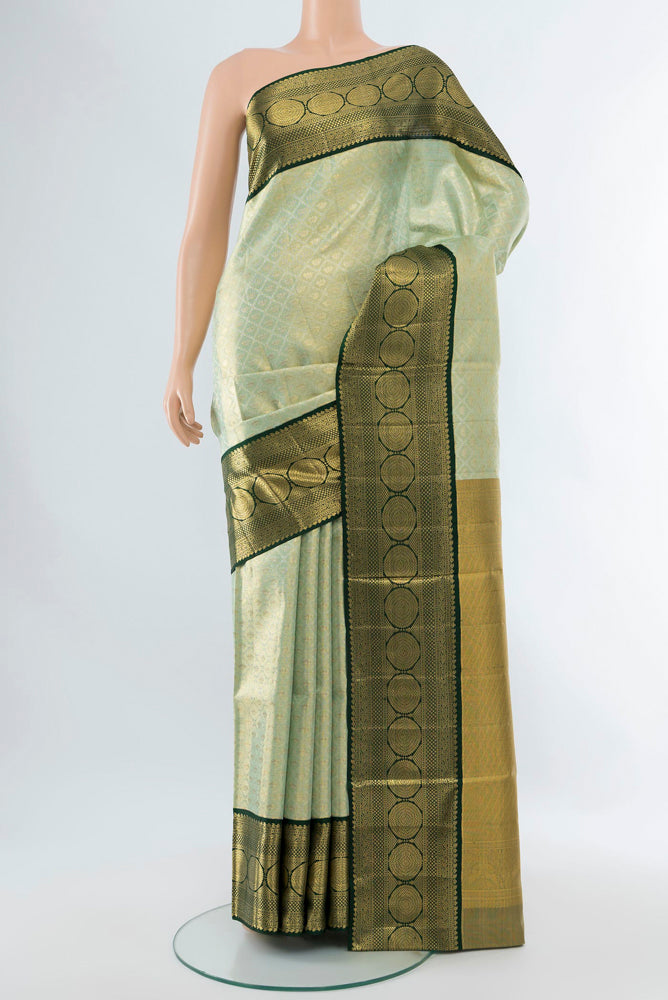 Pista Green Kanjivaram Silk Saree with Zari Butta on the body and Silk Border.  displayed on a mannequin