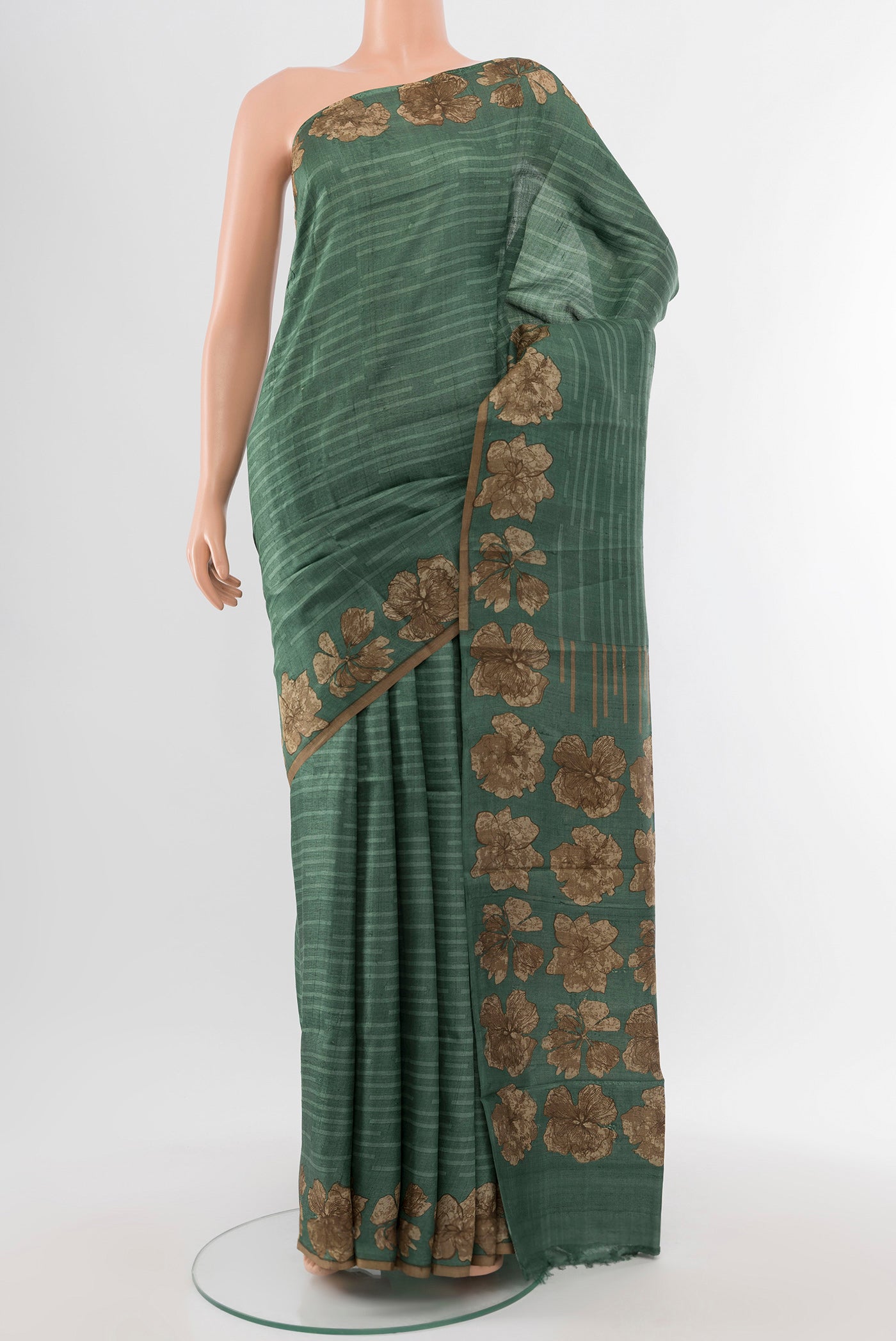 Light Green Tussar Silk Saree with Floral Print on the body and Silk Border.  displayed on a mannequin