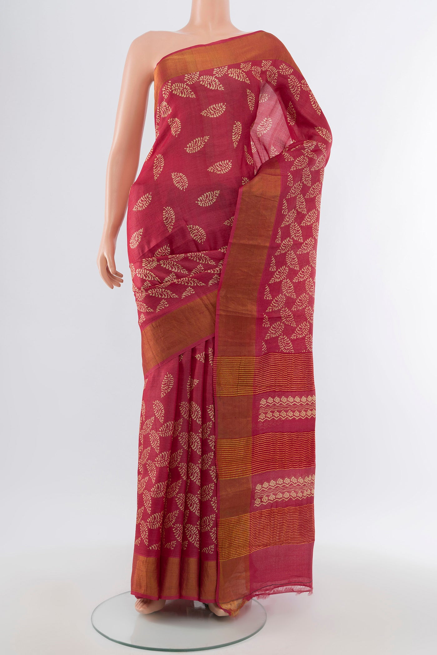 Peach Tussar Silk Saree with Floral Print on the body and Silk Border.  displayed on a mannequin