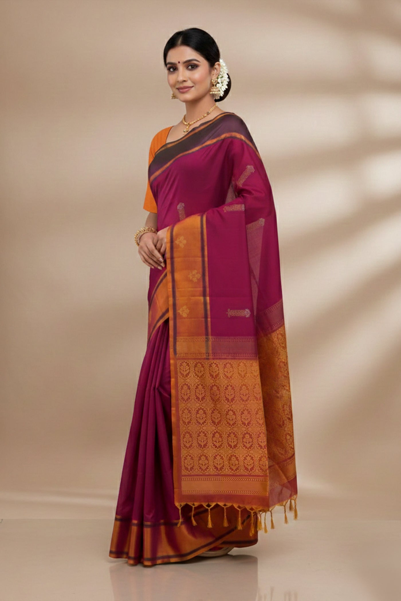 Model wearing a Magenta Soft Silk Saree with Zari Butta on the body and Plain Border