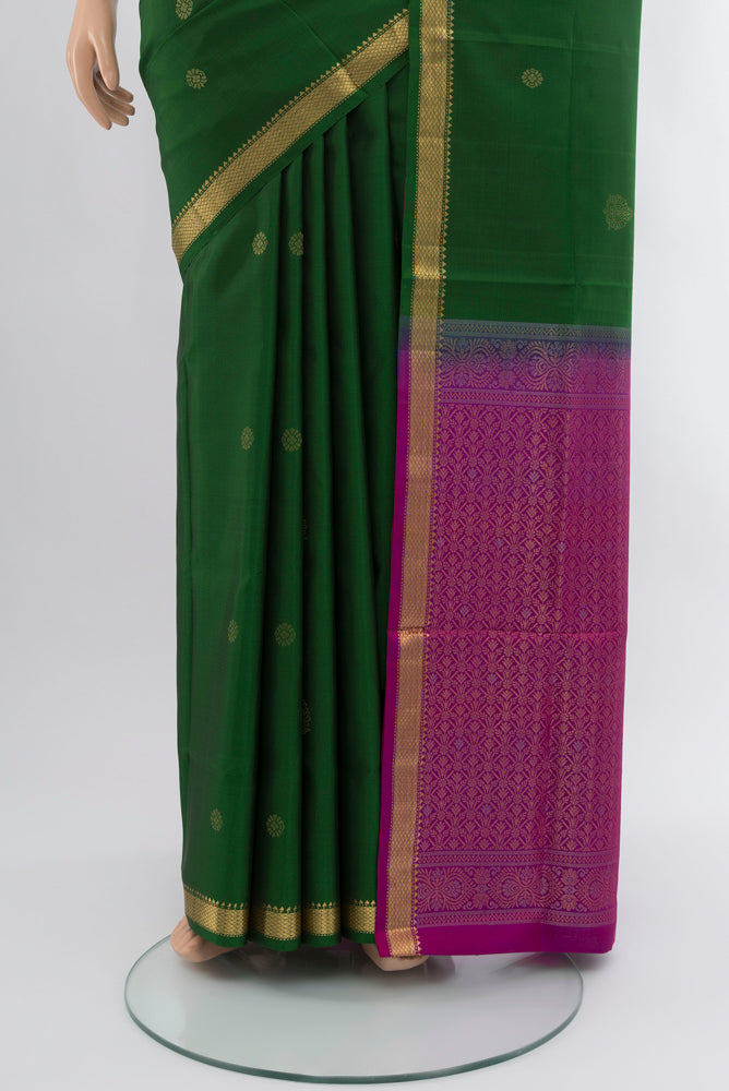 Pleats and pallu of Bottle Green Soft Silk Saree with Zari Butta on the body and Silk Border. 