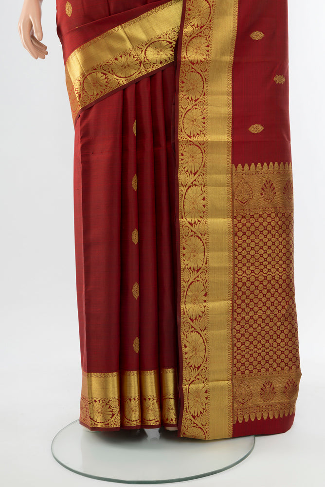 Pleats and pallu of Maroon Kanchipuram Silk Saree with Zari Butta on the body and Silk Border. 