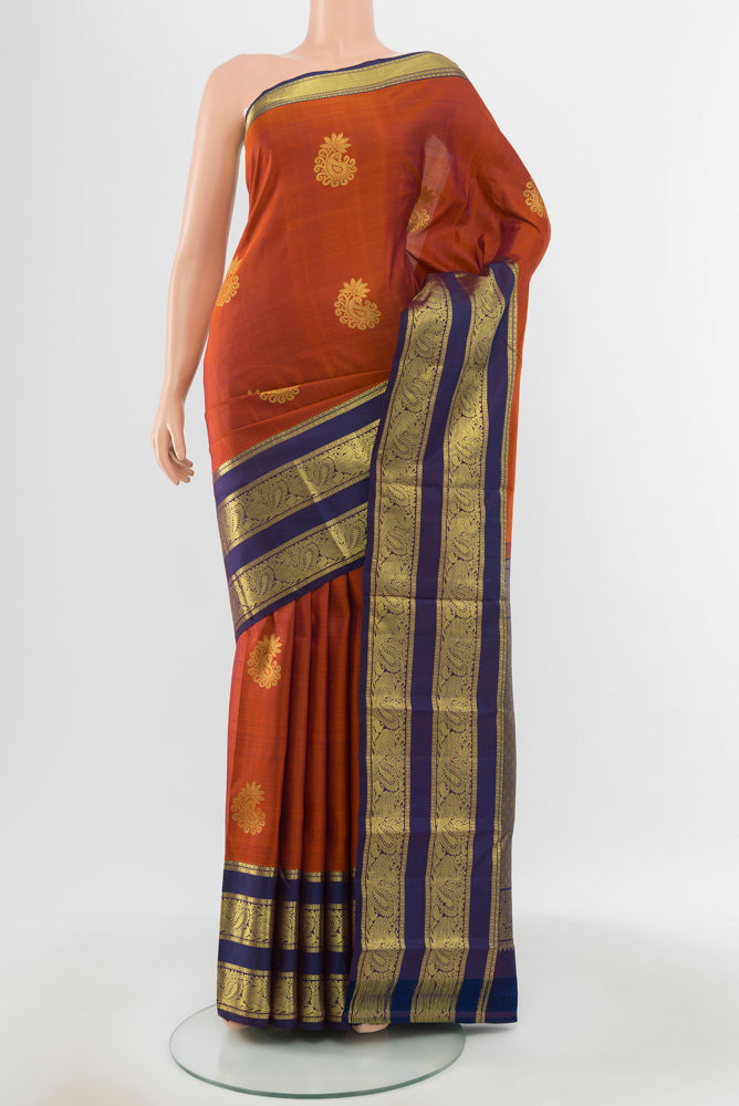 Pure Silk Pure Zari Rust Kanchipuram Saree with Zari Butta on the body and Silk Border.  displayed on a mannequin