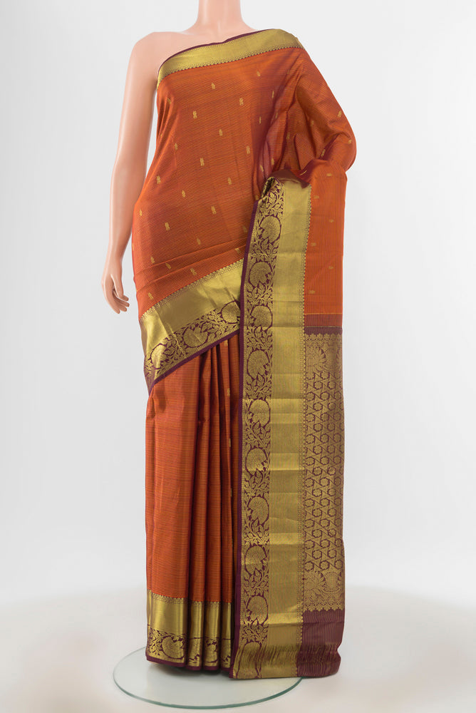 Pure Silk Pure Zari Rust Kanchipuram Saree with Zari Butta on the body and Silk Border.  displayed on a mannequin