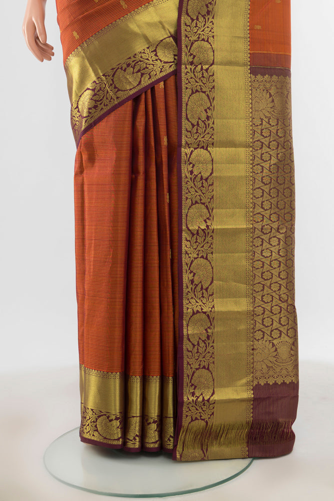 Pleats and pallu of Pure Silk Pure Zari Rust Kanchipuram Saree with Zari Butta on the body and Silk Border. 