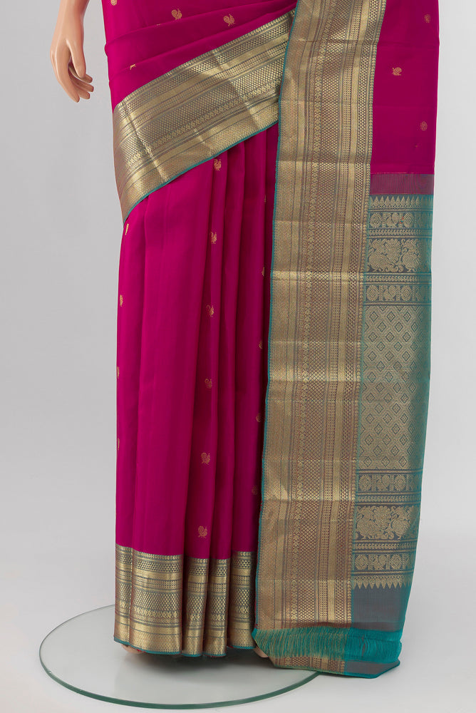 Pleats and pallu of Rani Pink Kanchipuram Silk Saree with Zari Butta on the body and Silk Border. 