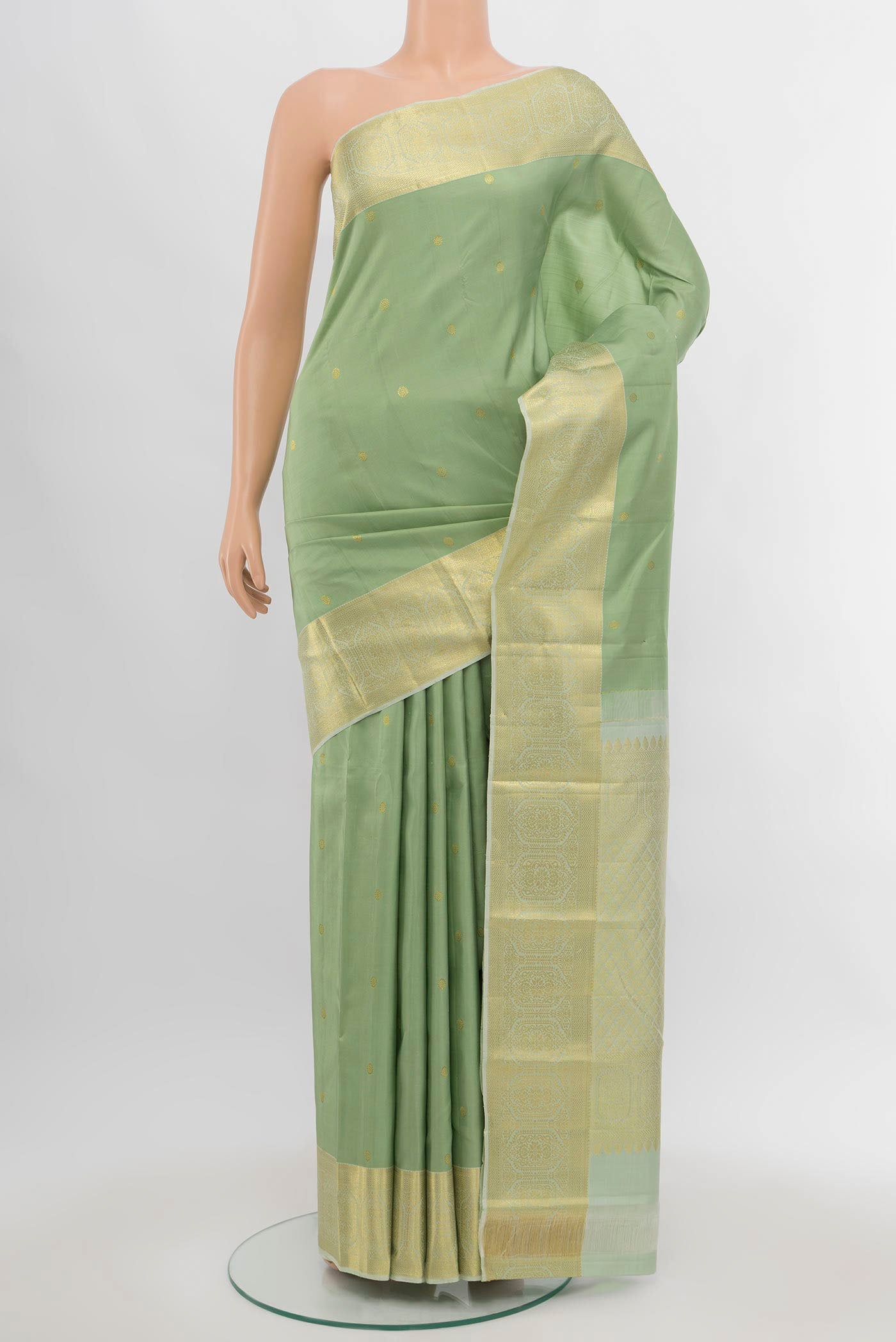 Pista Green Kanchipuram Silk Saree with Zari Butta on the body and Silk Border.  displayed on a mannequin