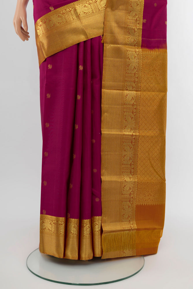 Pleats and pallu of Dark Pink Kanchipuram Silk Saree with Zari Butta on the body and Silk Border. 