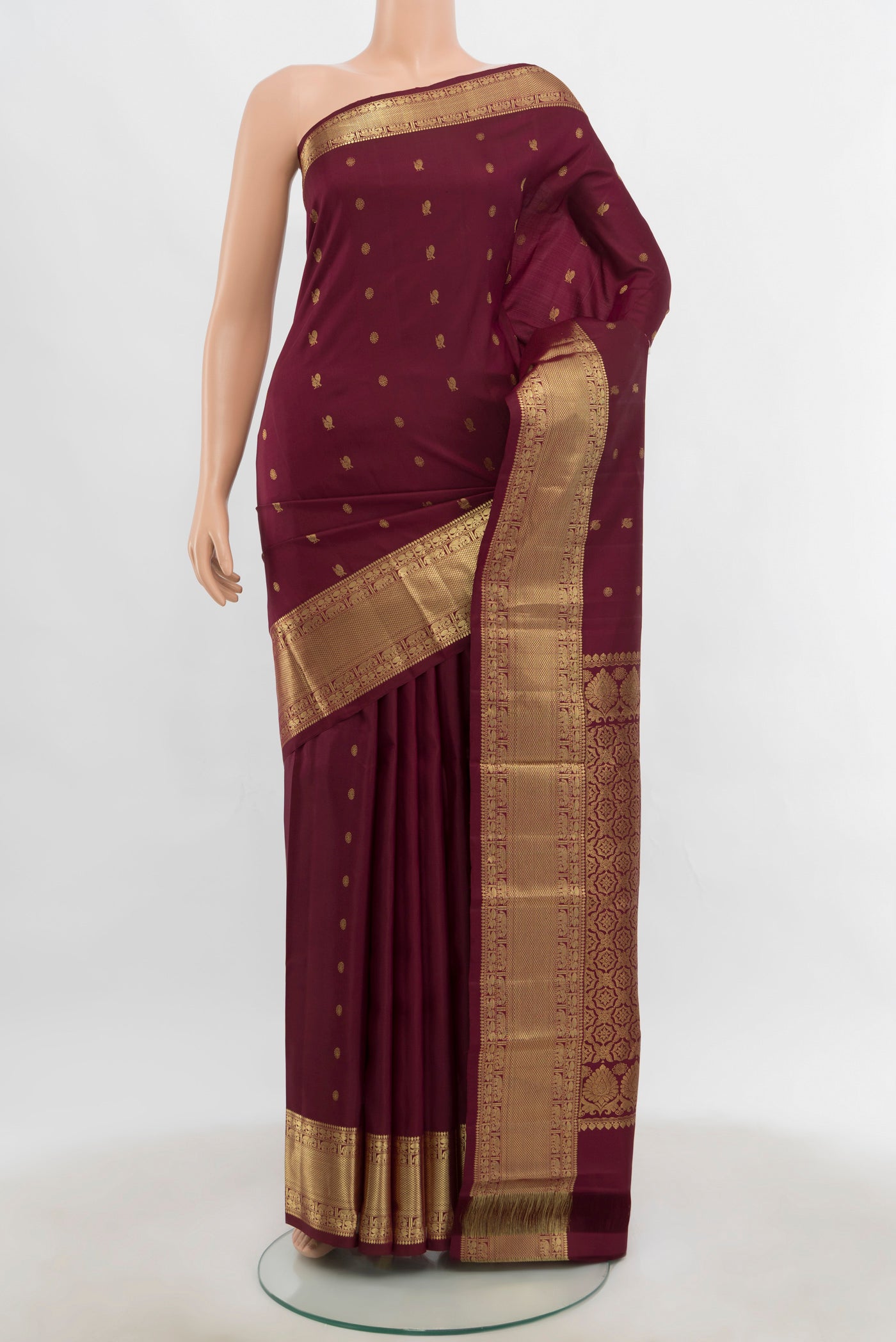 Pure Silk Pure Zari Maroon Kanchipuram Saree with Zari Butta on the body and Silk Border.  displayed on a mannequin