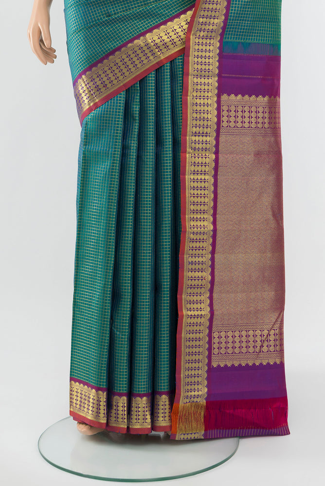 Pleats and pallu of Peacock Blue Kanjivaram Silk Saree with Zari Butta on the body and Silk Border. 