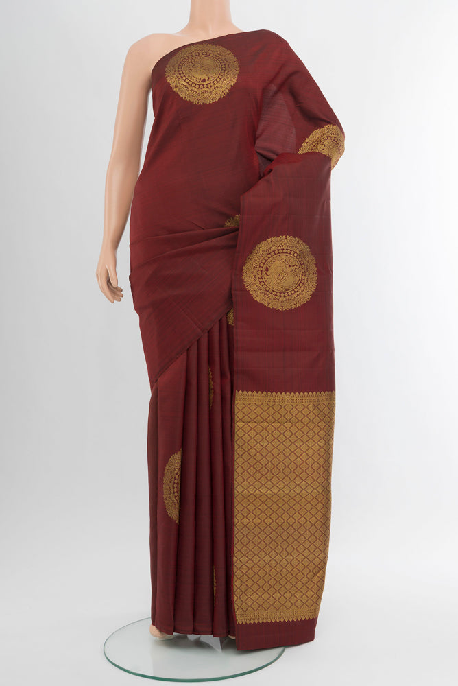 Pure Silk Pure Zari Maroon Kanchipuram Saree with Zari Butta on the body and Silk Border.  displayed on a mannequin