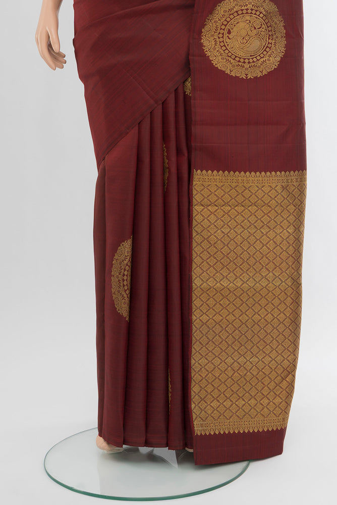 Pleats and pallu of Pure Silk Pure Zari Maroon Kanchipuram Saree with Zari Butta on the body and Silk Border. 