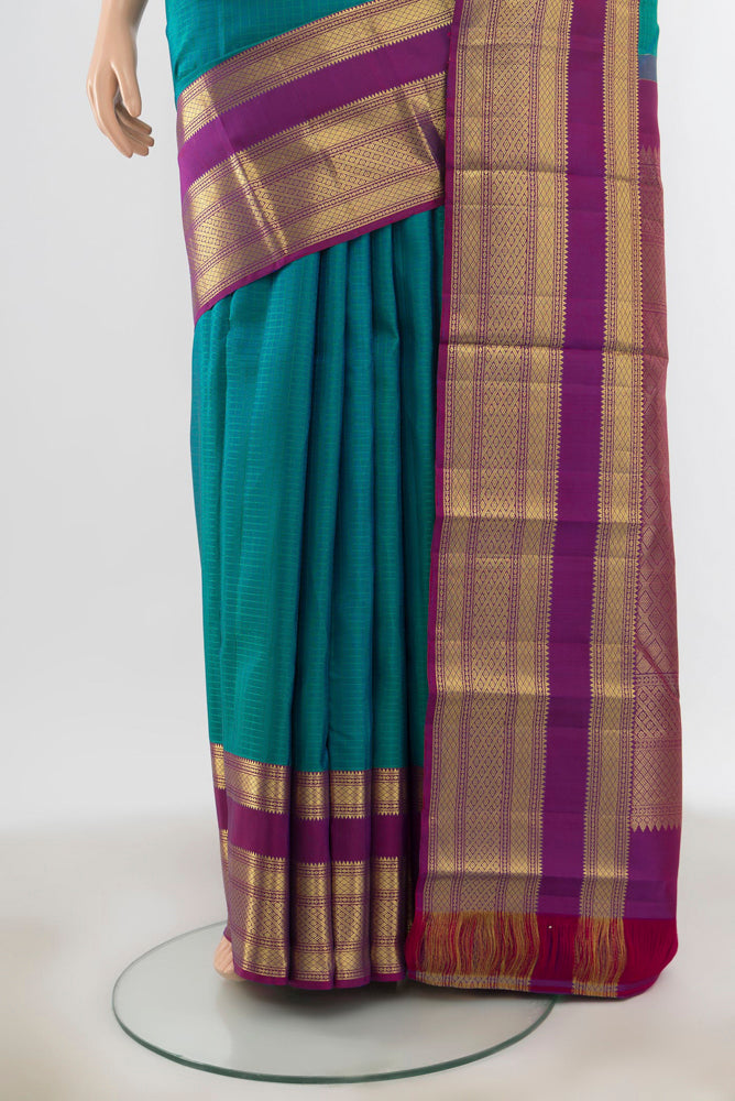 Pleats and pallu of Peacock Blue Kanjivaram Silk Saree with Zari Butta on the body and Silk Border. 