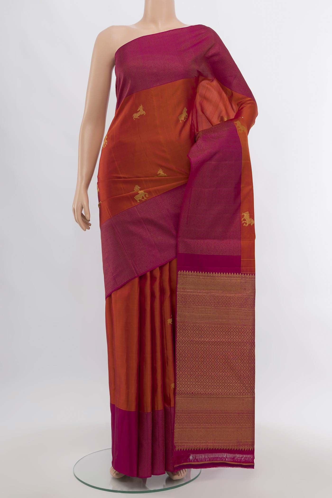 Rust Kanjivaram Silk Saree with Zari Butta on the body and Silk Border.  displayed on a mannequin