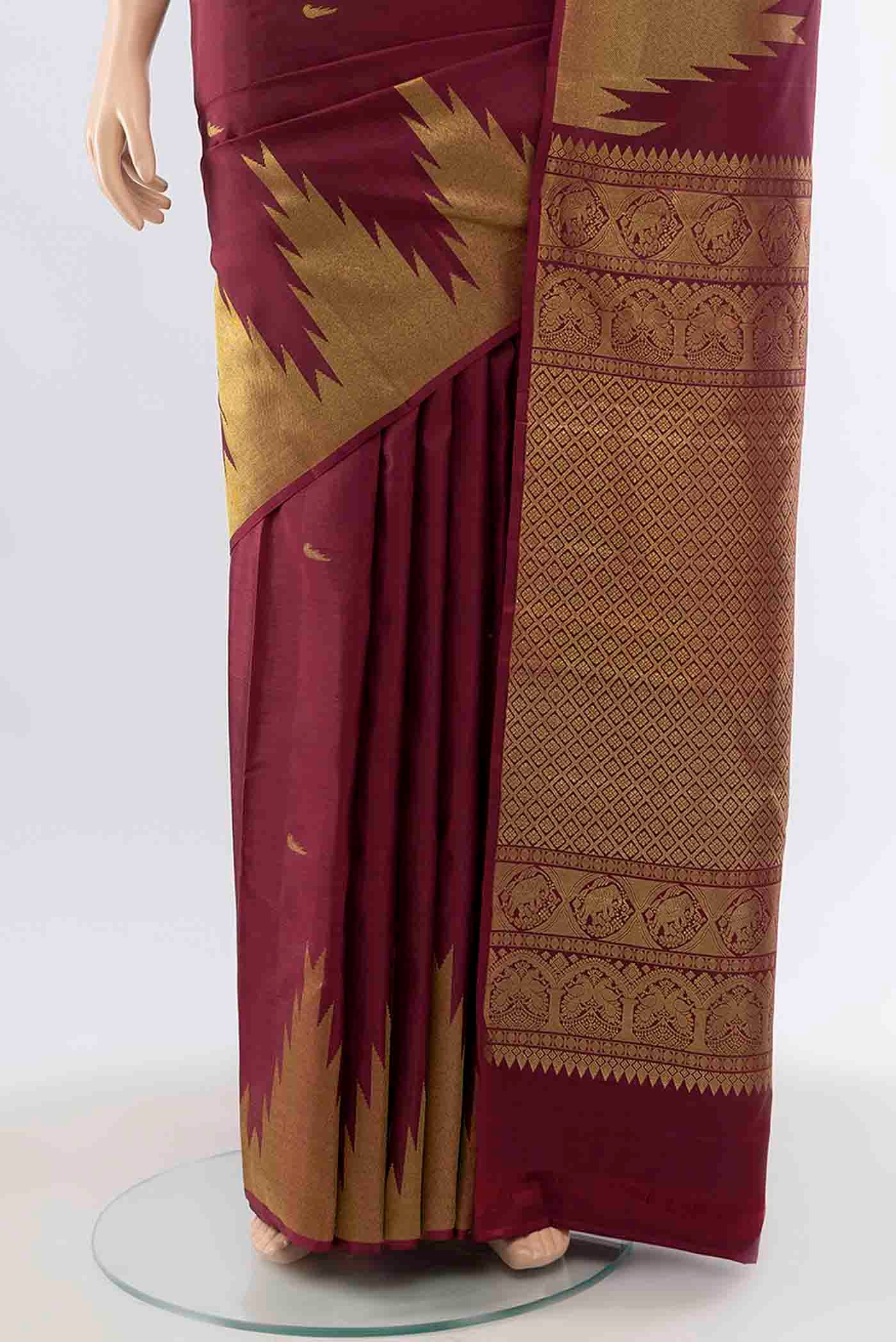 Pleats and pallu of Maroon Kanchipuram Silk Saree with Zari Butta on the body and Temple Border