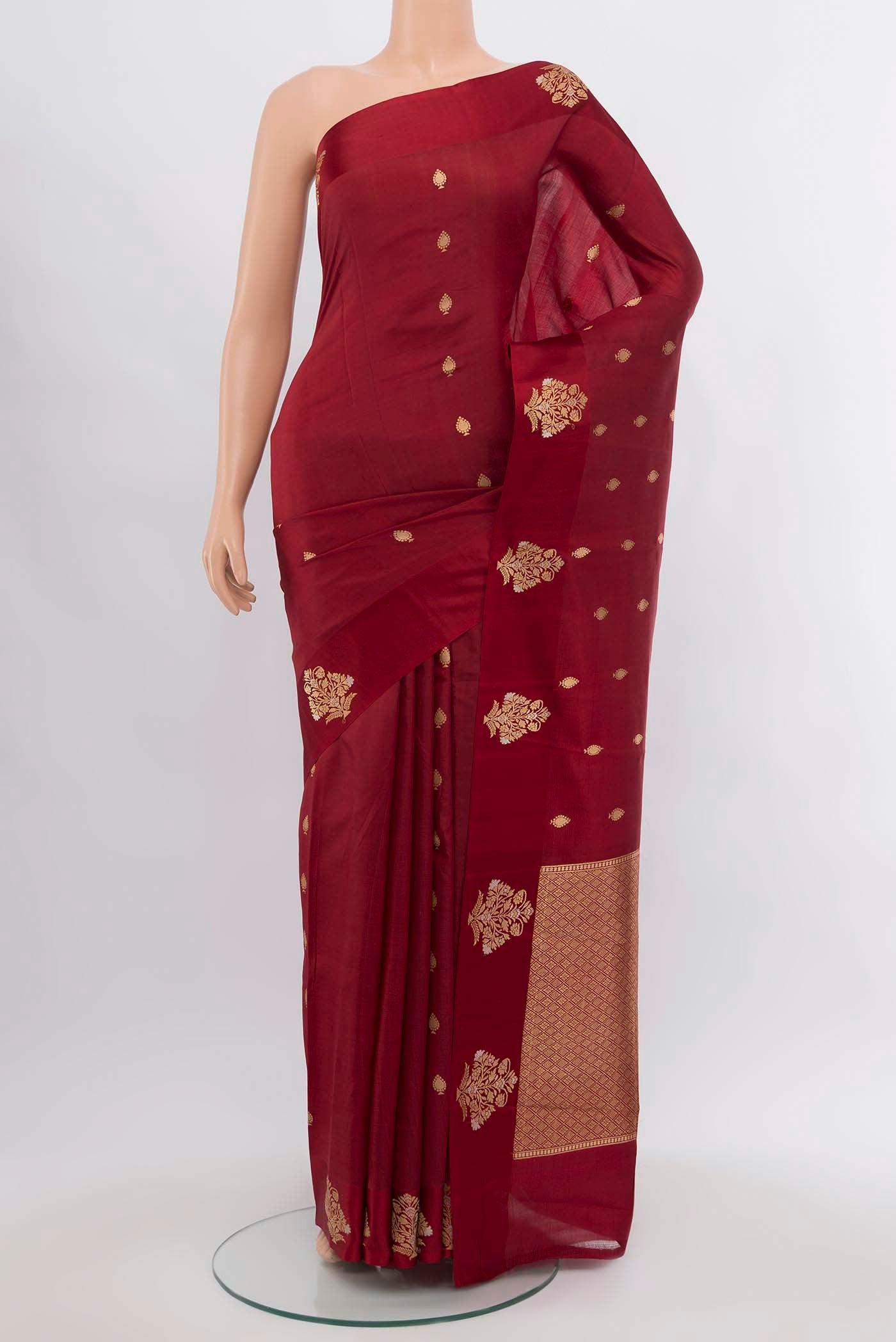 Maroon Banarasi Katan Silk Saree with Zari Butta on the body and Silk Border.  displayed on a mannequin