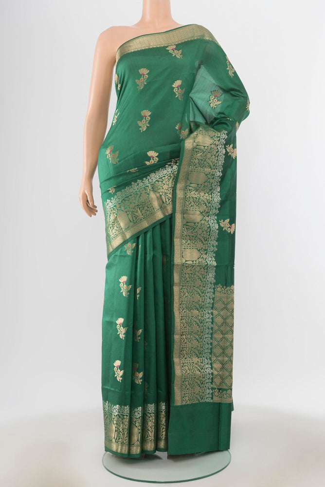 Bottle Green Banarasi Raw Silk Saree with Zari Butta on the body and Silk Border.  displayed on a mannequin