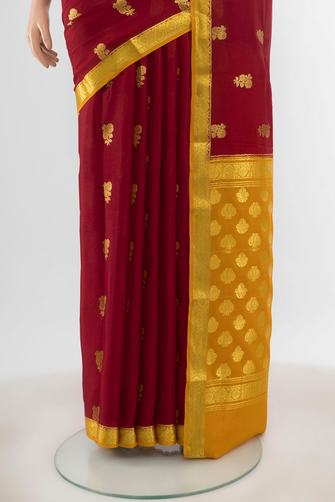 Pleats and pallu of Maroon Georgette Saree with Zari Butta on the body and Silk Border. 