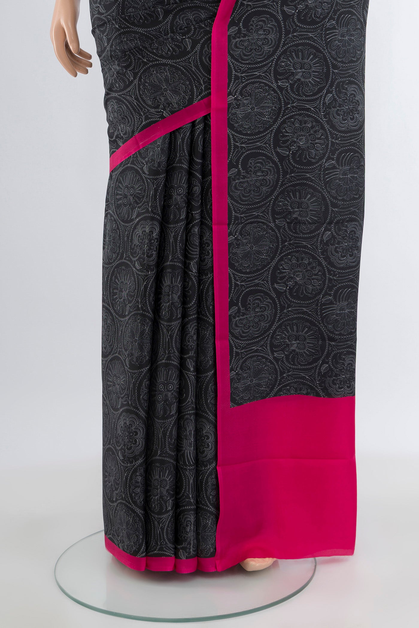 Pleats and pallu of Black Printed Silk Saree with Floral Print on the body and Plain Border. 