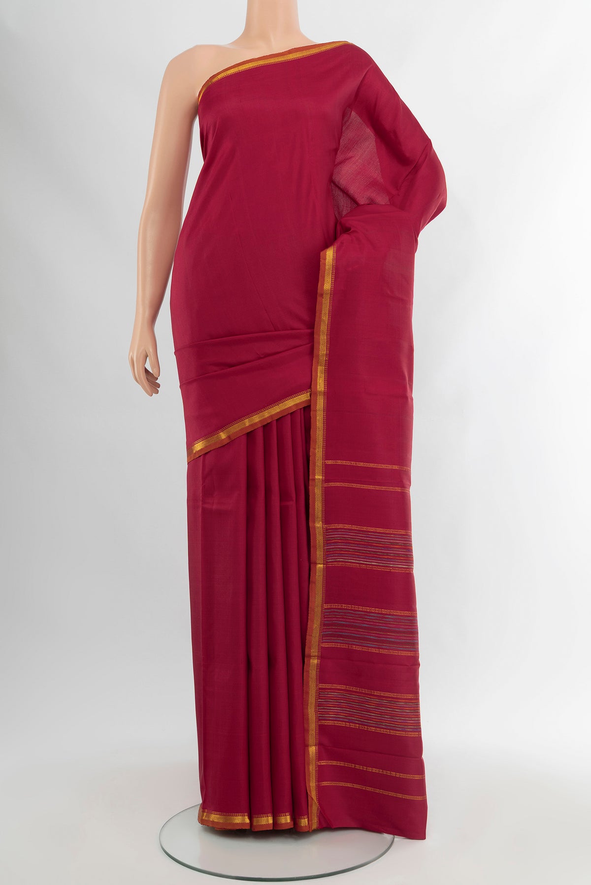 Maroon Kanchipuram Silk Saree with Plain Body and Zari Border.  displayed on a mannequin