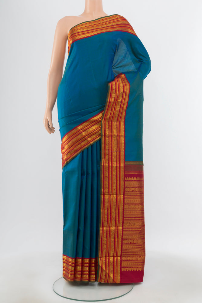 Pure Silk Pure Zari Peacock Blue Kanjivaram Saree with Zari Butta on the body and Silk Border.  displayed on a mannequin