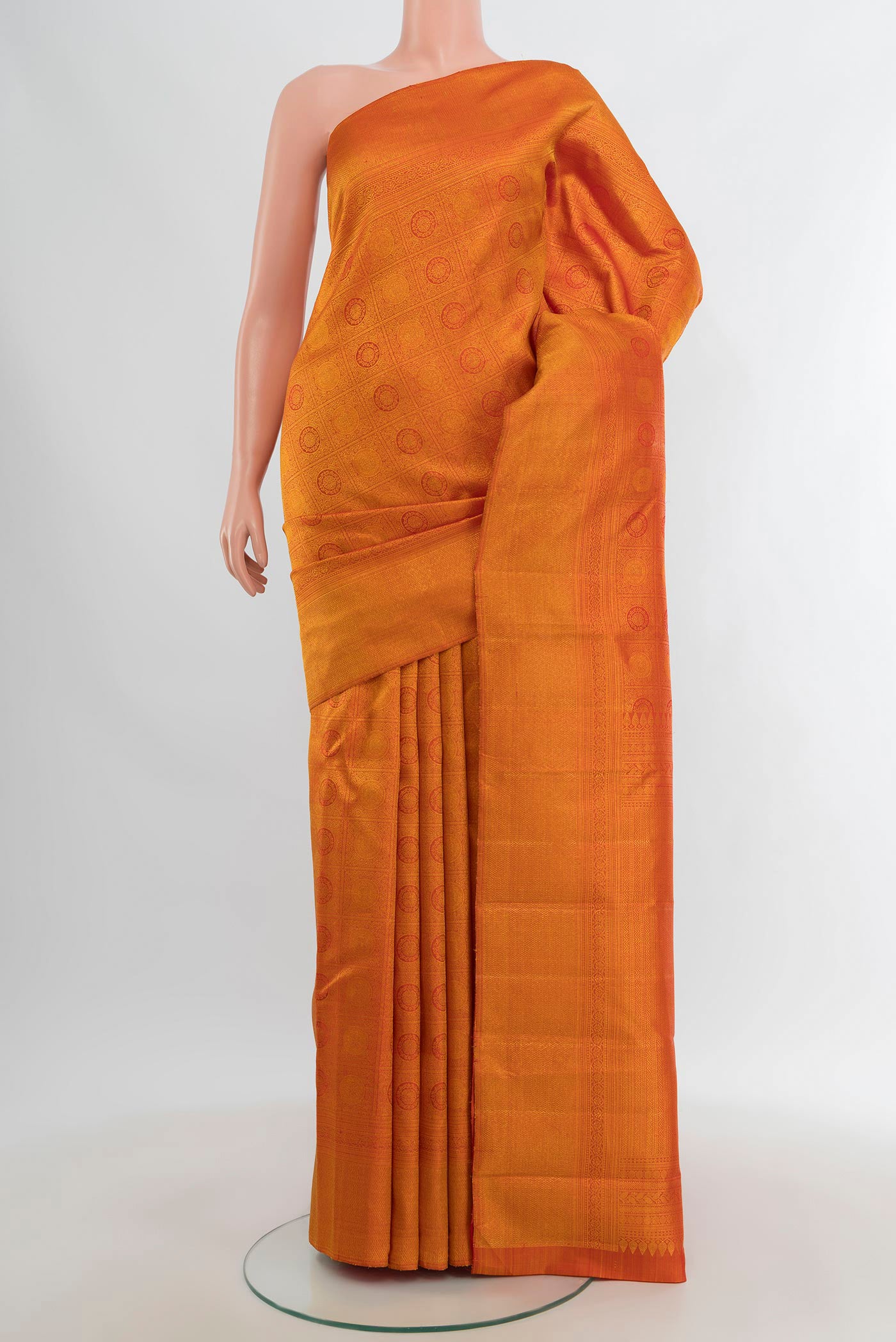 Brick Orange Kanchipuram Silk Saree with Zari Brocade on the body and Zari Border.  displayed on a mannequin