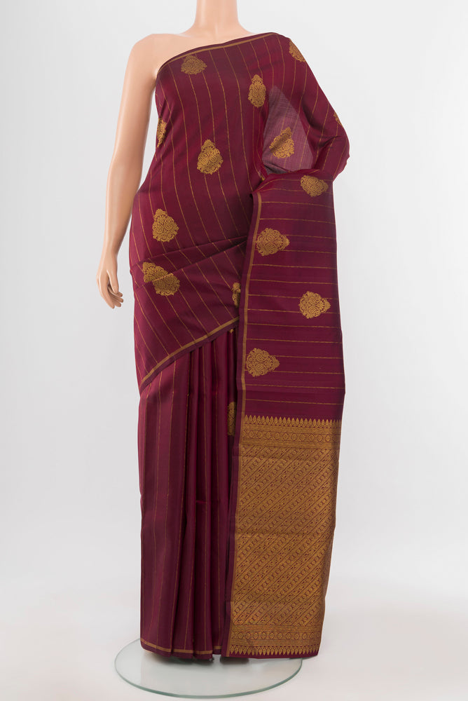 Maroon Kanjivaram Silk Saree with Zari Butta on the body and Silk Border.  displayed on a mannequin