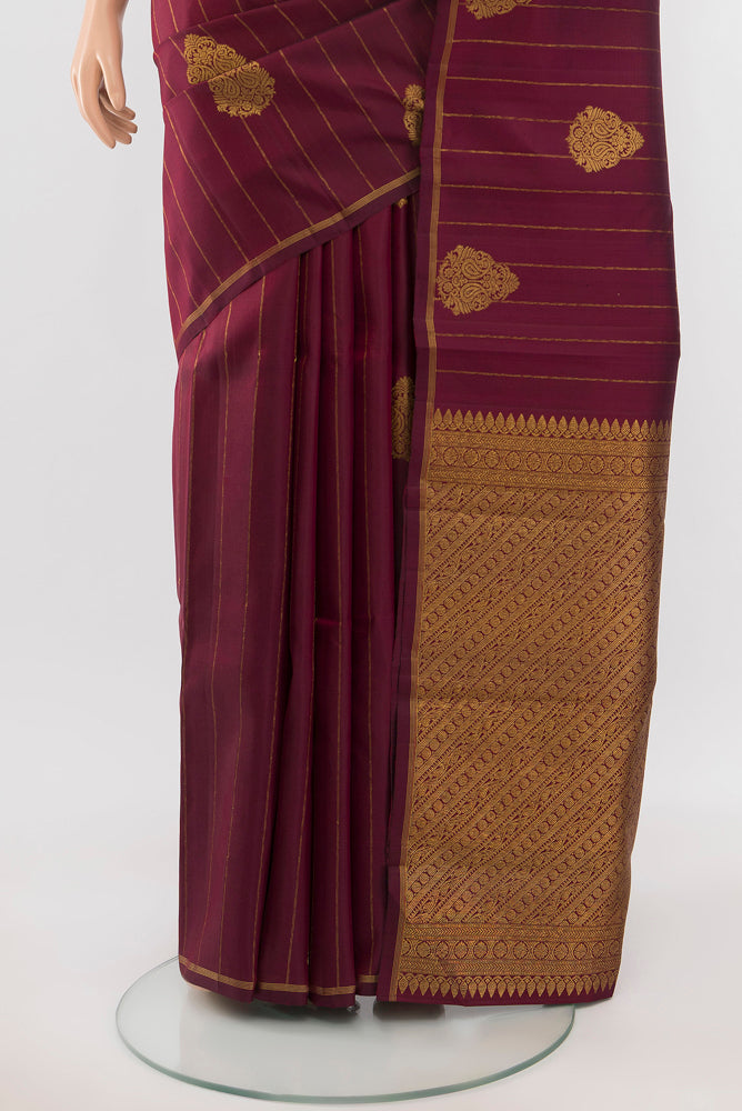 Pleats and pallu of Maroon Kanjivaram Silk Saree with Zari Butta on the body and Silk Border. 