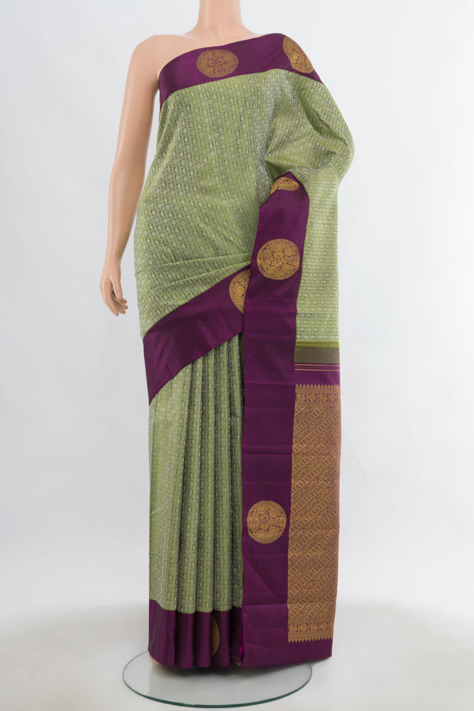 Light Green Kanjivaram Silk Saree with Zari Butta on the body and Fancy Border.  displayed on a mannequin