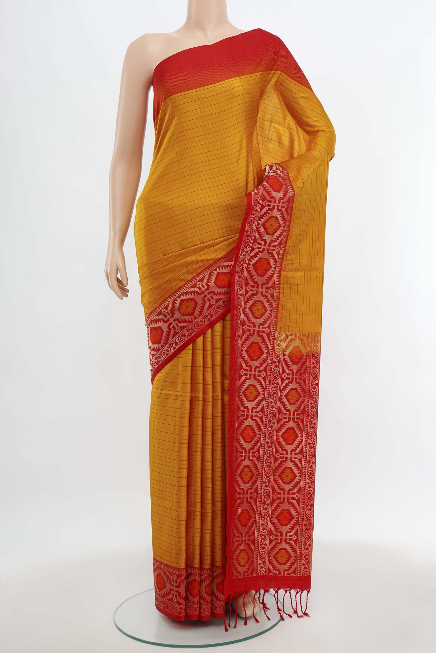Mustard Soft Silk Saree with Zari Butta on the body and Silk Border.  displayed on a mannequin