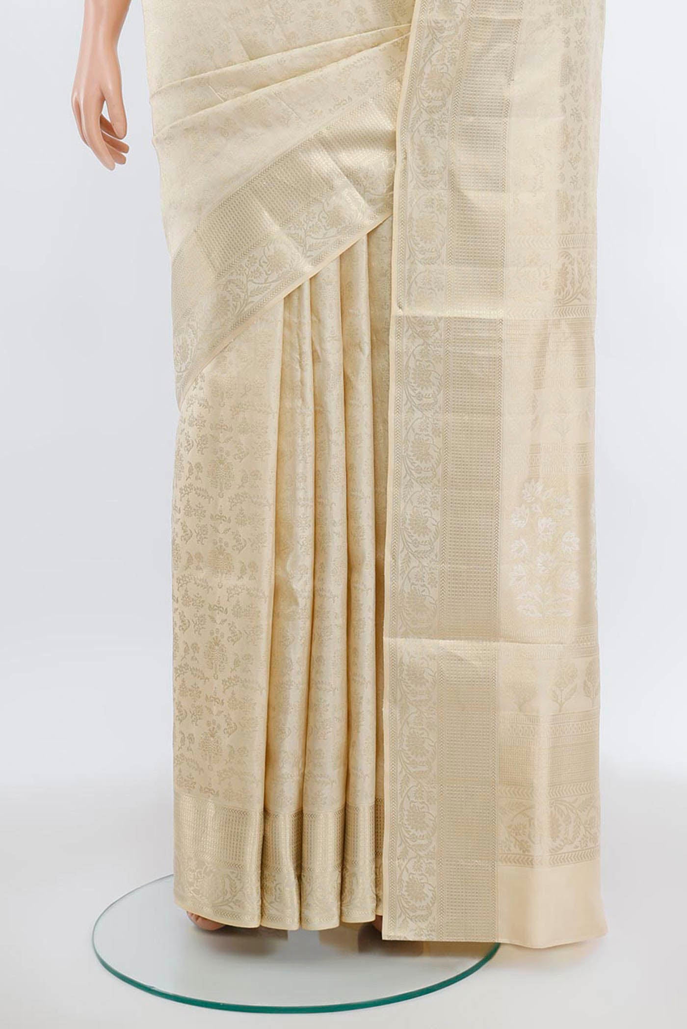 Pleats and pallu of Cream Soft Silk Saree with Zari Butta on the body and Silk Border. 