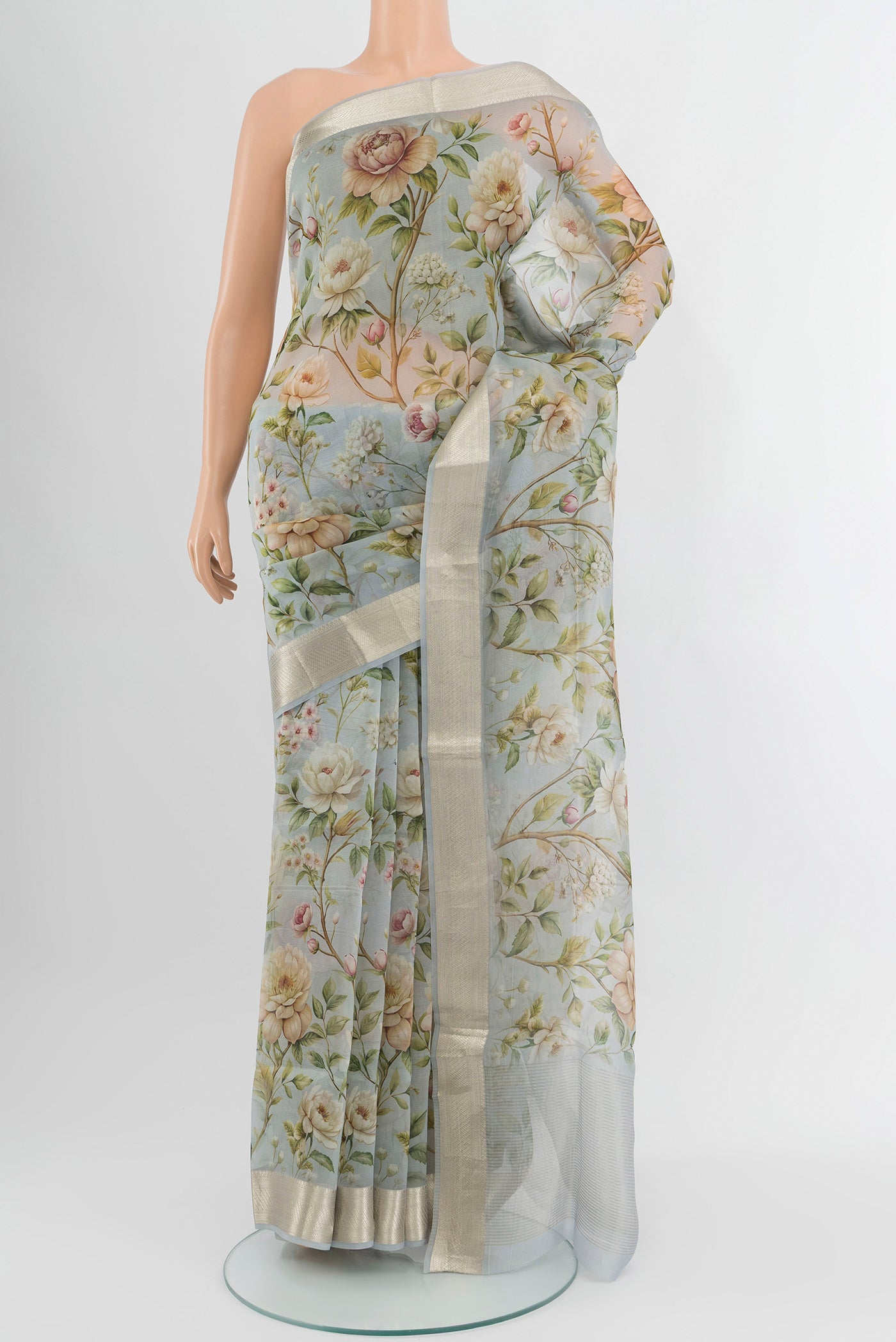 Light Blue Organza Silk Saree with Floral Print on the body and Zari Border.  displayed on a mannequin