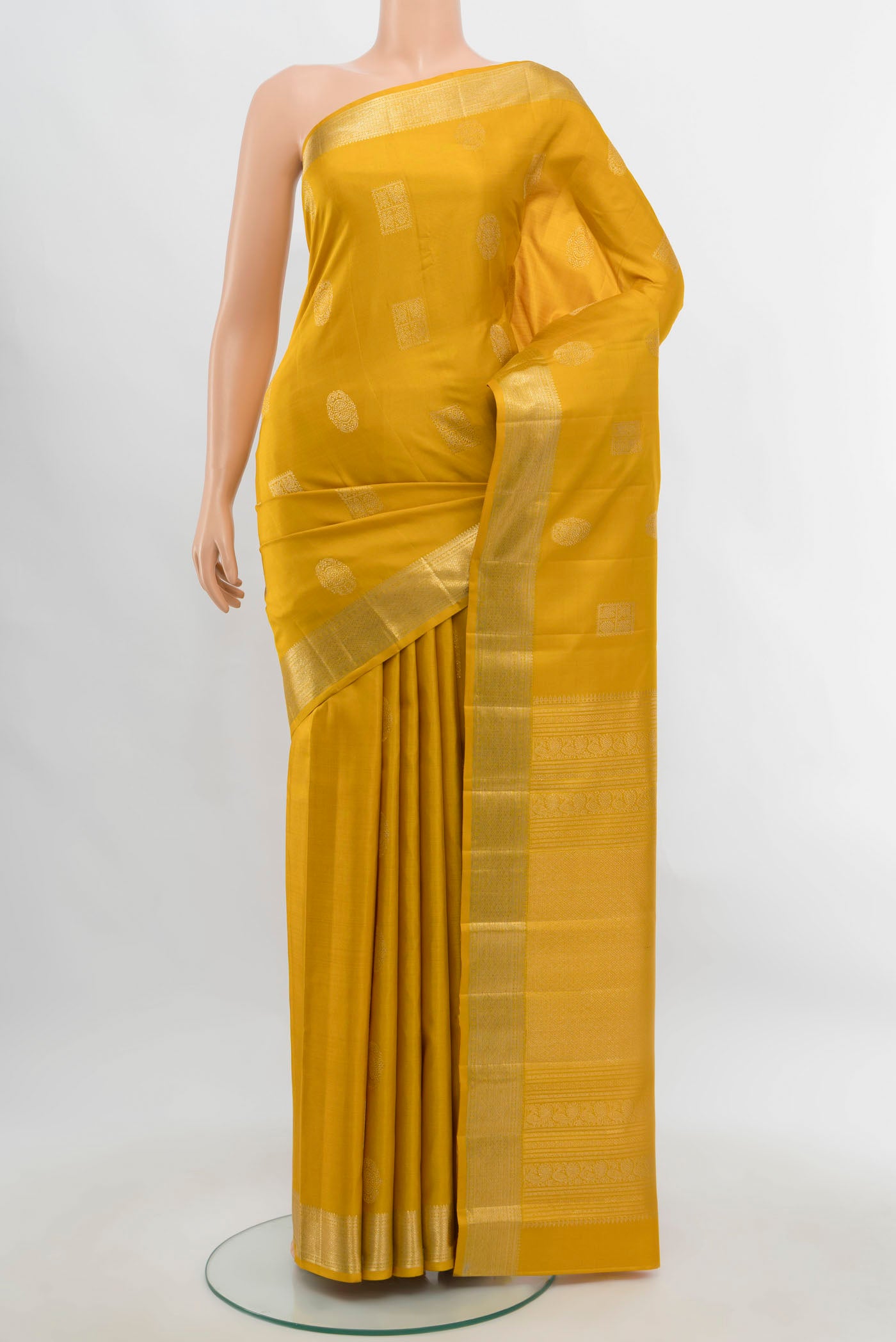 Yellow Kanjivaram Silk Saree with Zari Butta on the body and Silk Border.  displayed on a mannequin