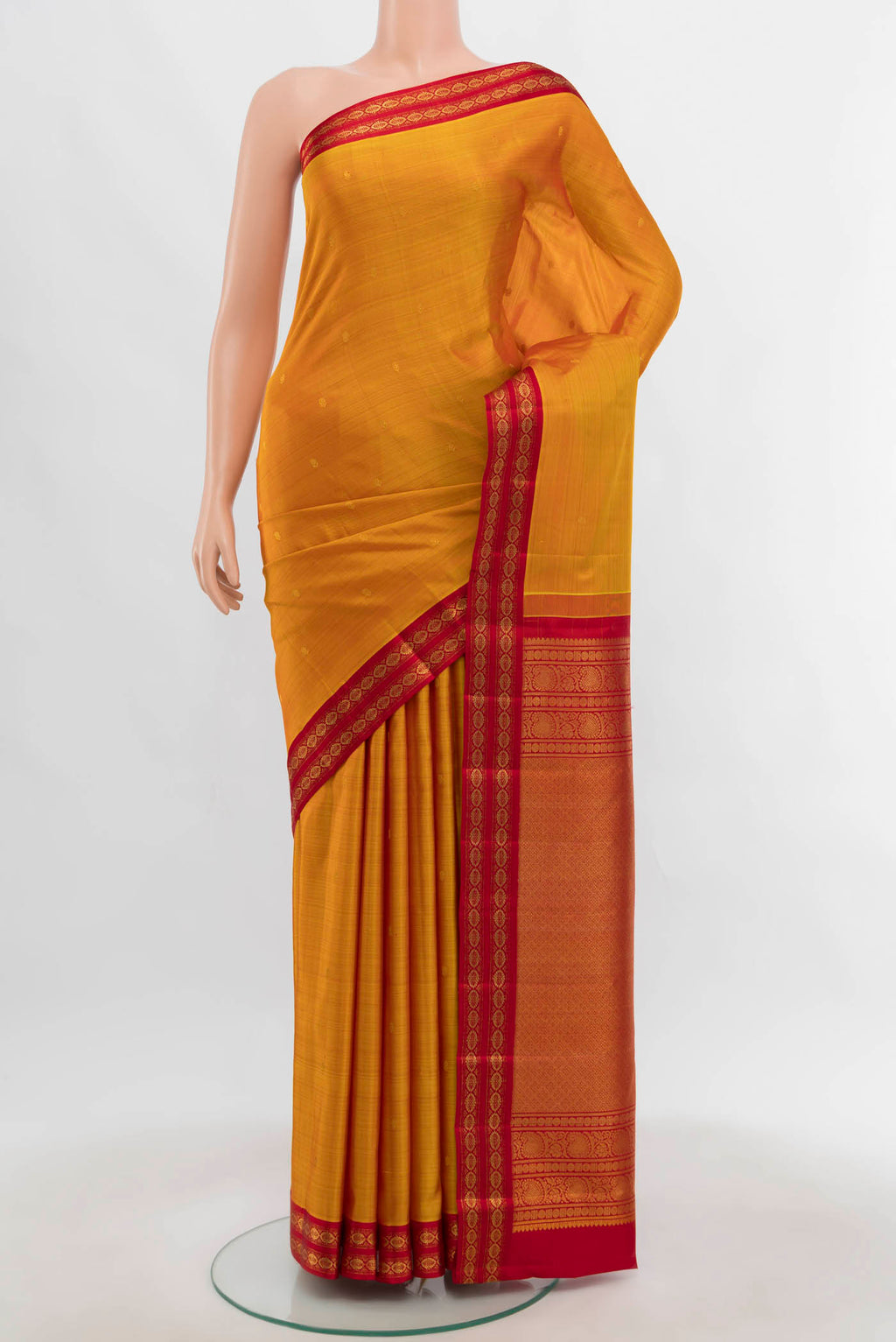 Mustard Kanchipuram Silk Saree with Zari Butta on the body and Zari Border.  displayed on a mannequin