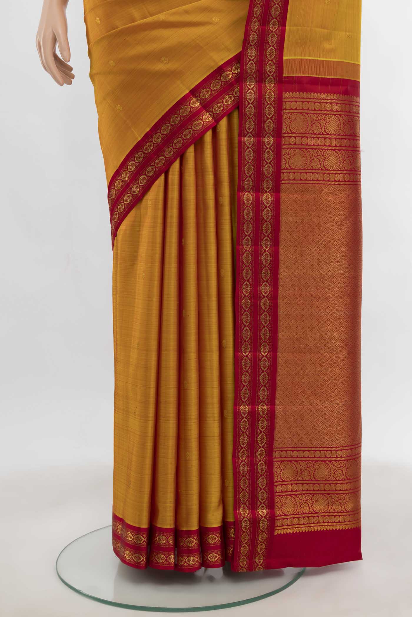 Pleats and pallu of Mustard Kanchipuram Silk Saree with Zari Butta on the body and Zari Border. 