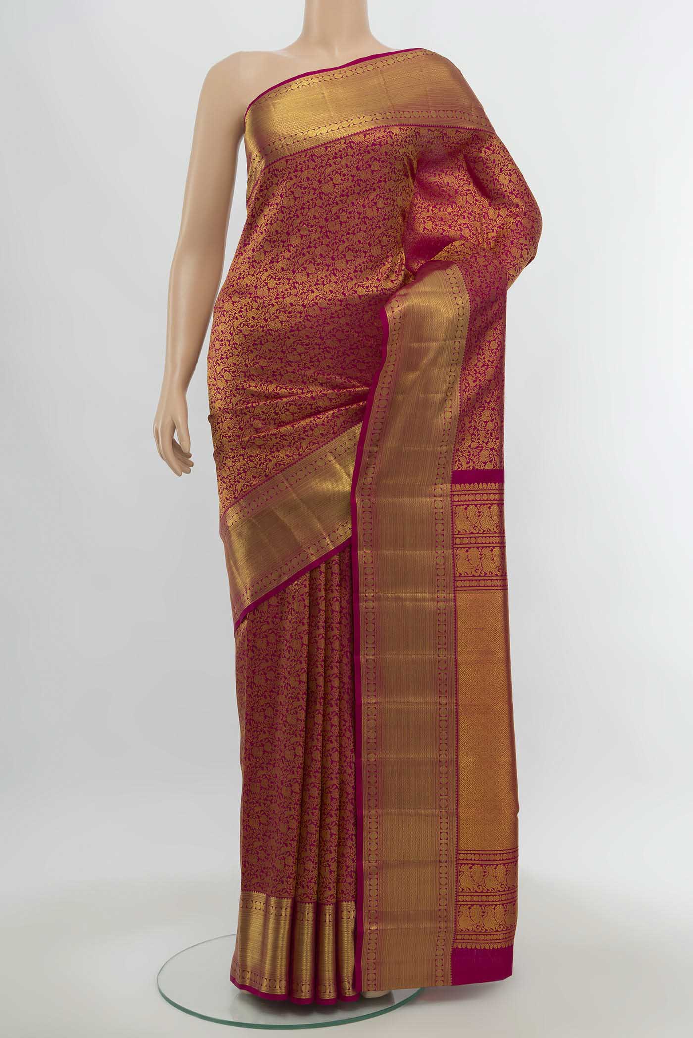 Magenta Kanchipuram Silk Saree with Zari Butta on the body and Silk Border.  displayed on a mannequin