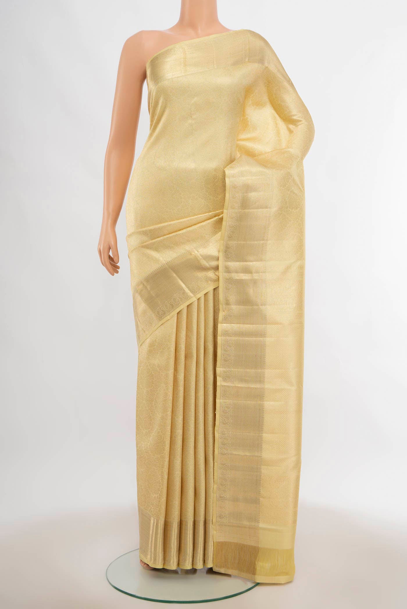 Cream Kanchipuram Silk Saree with Zari Butta on the body and Silk Border.  displayed on a mannequin