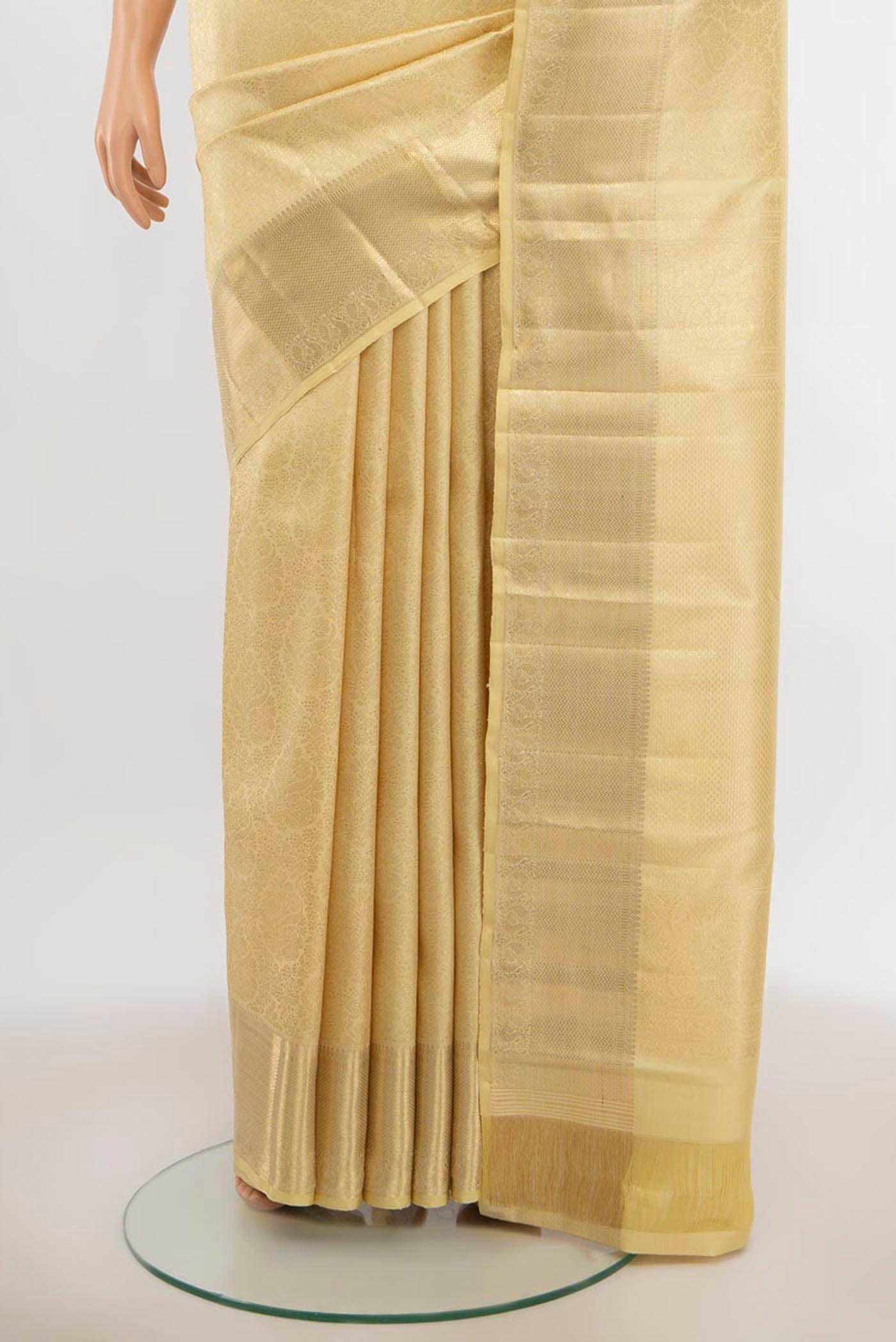 Pleats and pallu of Cream Kanchipuram Silk Saree with Zari Butta on the body and Silk Border. 