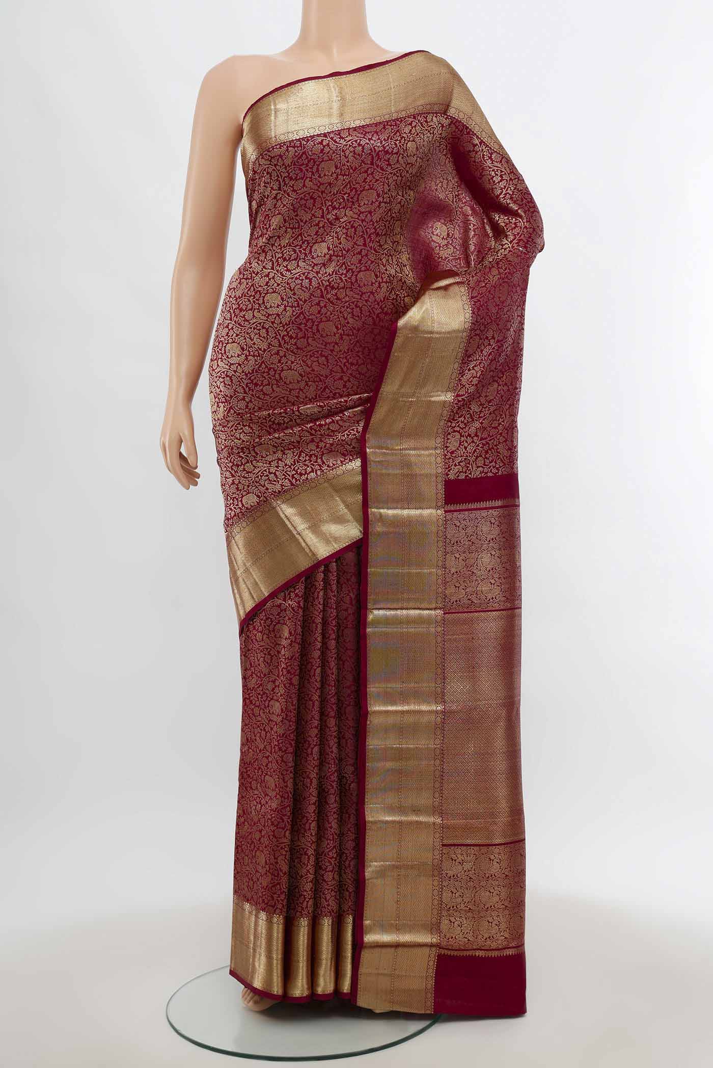 Maroon Kanchipuram Silk Saree with Zari Butta on the body and Silk Border.  displayed on a mannequin
