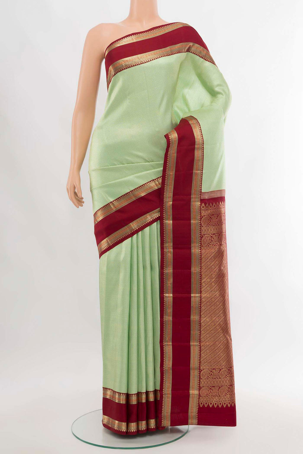 Pista Green Kanchipuram Silk Saree with Zari Butta on the body and Silk Border.  displayed on a mannequin