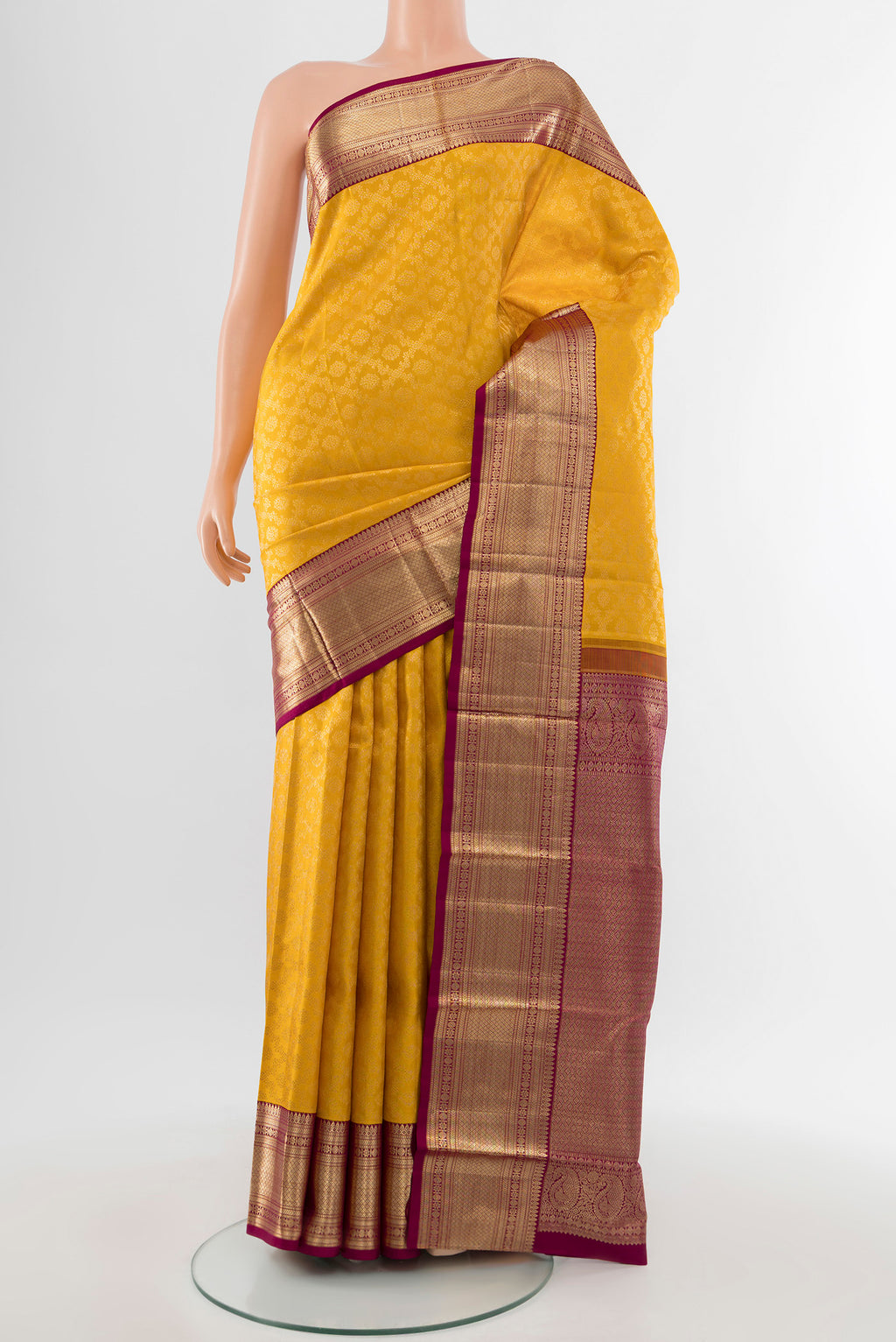 Pure Silk Pure Zari Mustard Kanchipuram Saree with Zari Butta on the body and Silk Border.  displayed on a mannequin