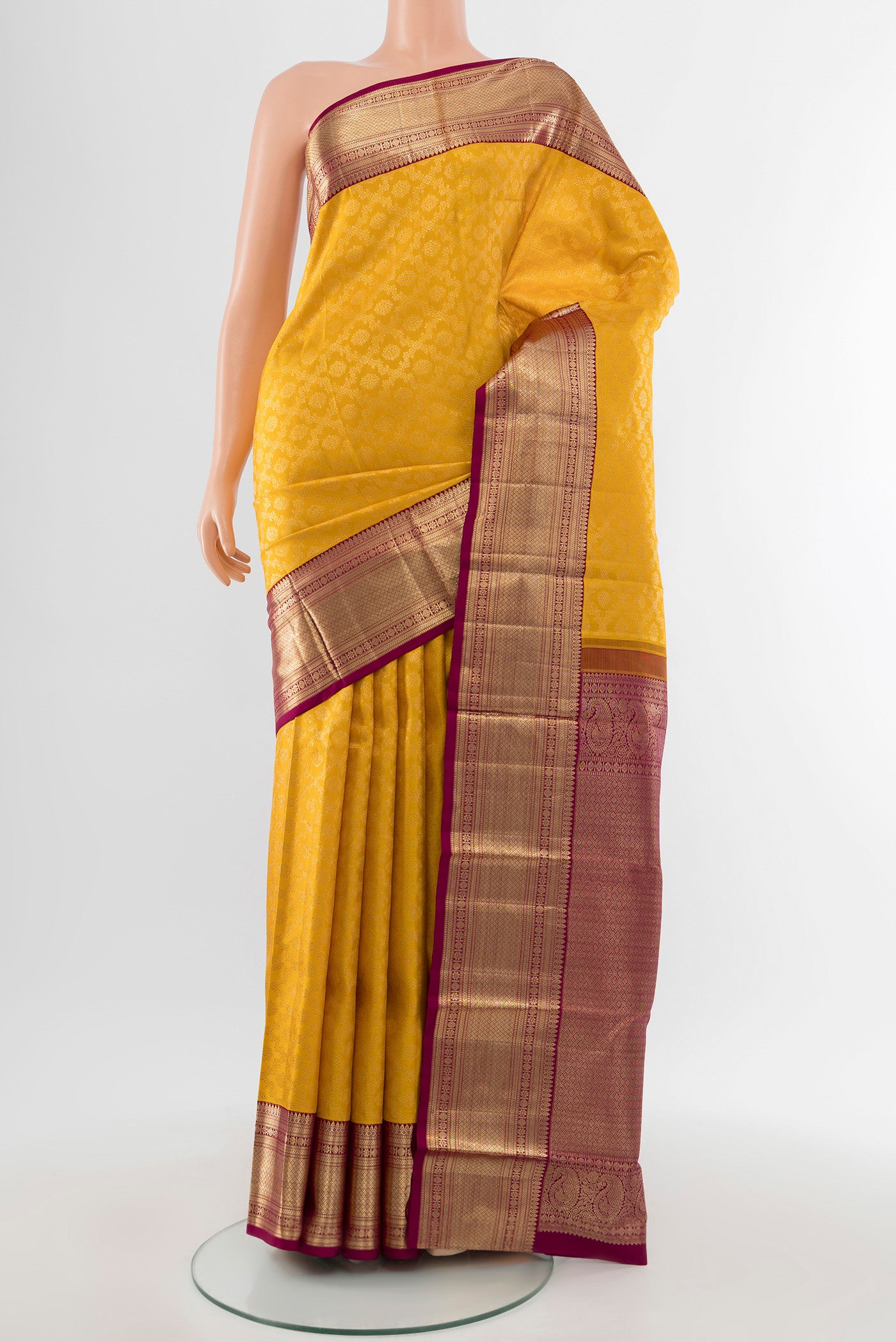 Pure Silk Pure Zari Mustard Kanchipuram Saree with Zari Butta on the body and Silk Border.  displayed on a mannequin