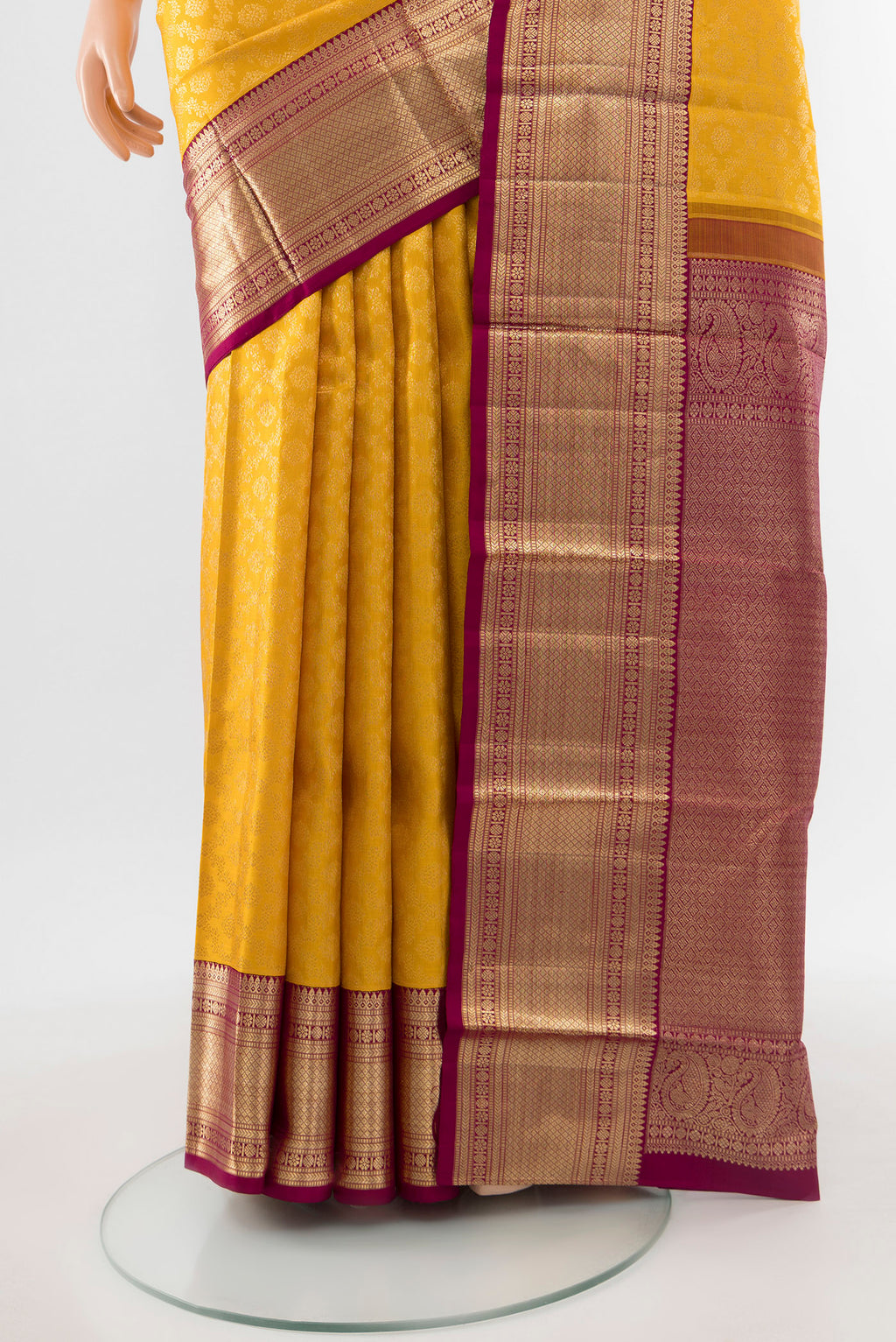 Pleats and pallu of Pure Silk Pure Zari Mustard Kanchipuram Saree with Zari Butta on the body and Silk Border. 